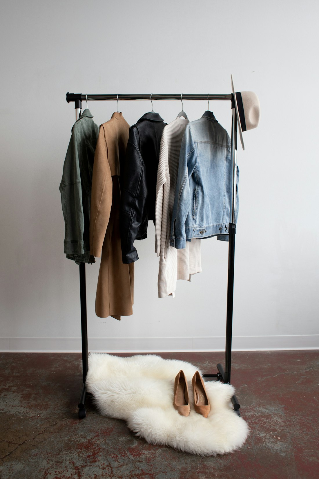 A clothes rail of jackets and coats against a white wall